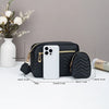 Black quilted crossbody bag next to a phone for size